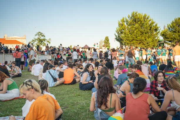 Lisbon, Portugal. 17 June 2023 People relaxing and having fun in park during Pride Parade. Happy free people sitting on lawn, communicating and playing ball at lgbtqia pride event in park Lisbon