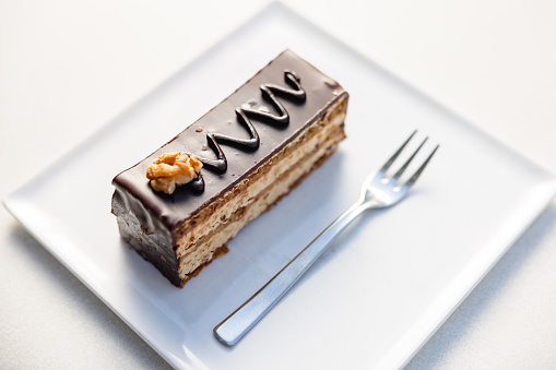 A walnut layer cake covered in chocolate and candied walnuts, then topped with moist chocolate.