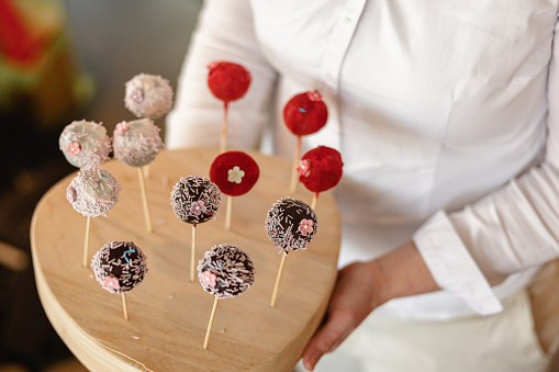 Sweet cake pops made of chocolate and decorated with confetti.