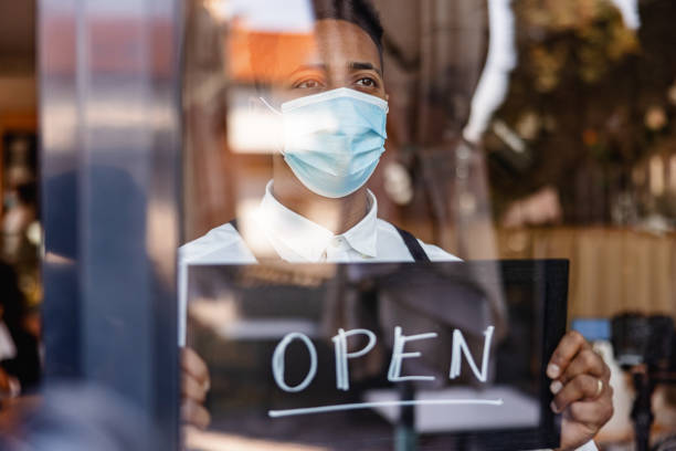istock A Waiter Holding An Open Sign On The Window 1959656496