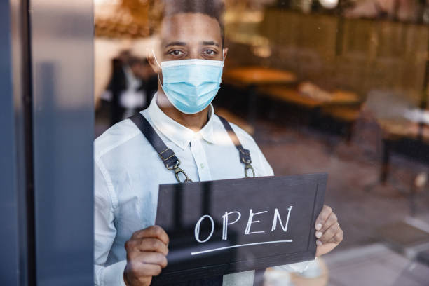 istock A Waiter Holding An Open Sign On The Window 1959656506