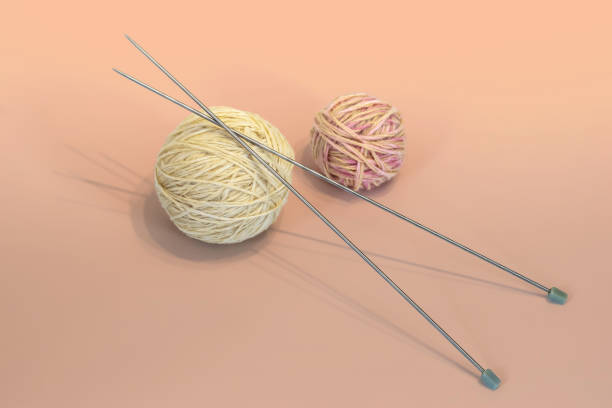 Female hobby knitting. Yarn in warm colors. Peach, beige, white. The beginning of the knitting process stock photo
