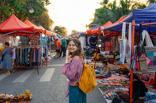 Woman exploring street  market in Luang Prabang during her vacation to Southeast Asia