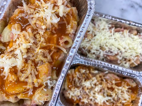 Cheesy Scotel Macaroni Baked Creamy in aluminum  foil container on the table