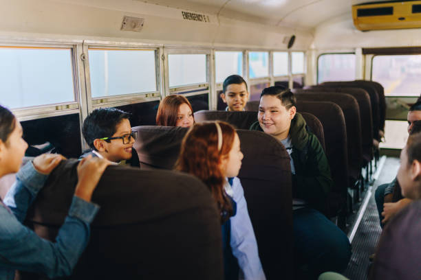 istock Friends students talking on the school bus 1959674211