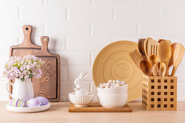 istock Kitchen wooden countertop with kitchen utensils and festive decorations for the spring Easter holiday. Front view. White brick wall. 1959690699