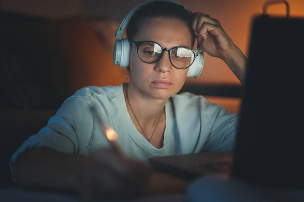 istock Young woman working at home at night on a project using a laptop. Online education 1959691739