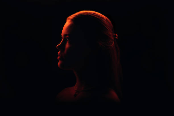 istock Gorgeous Young Woman Modelling In Red Light, Serious Profile Looking Straight 1959718427