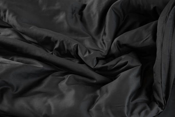 istock Texture of black satin bed linen with waves fabric 1959740278