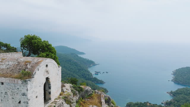 Aerial view of old ruined chapel or church with sea view on the top of the mountain in Kayakoy, Fethiye