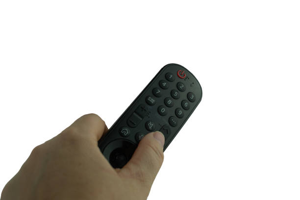 istock detail of a hand holding and pointing a remote control at a television remote control. 1959771993