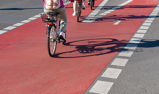 Germany, Berlin, November 01, 2023 - Woman on bicycle driving on red bicycle lane, Berlin Schöneberg
