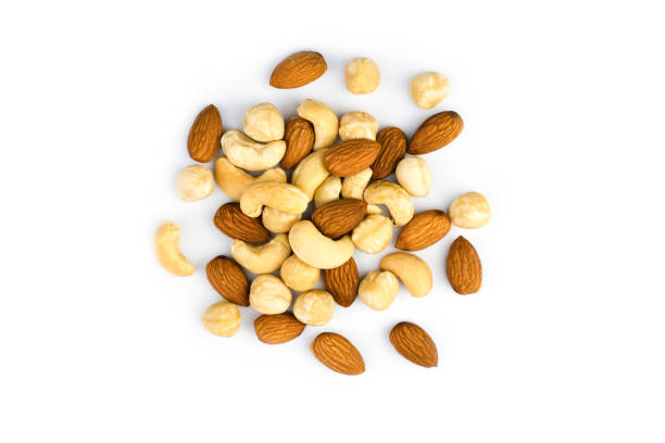 Close up of woman's hands spilling out nuts and seeds from container to the the palm of hand