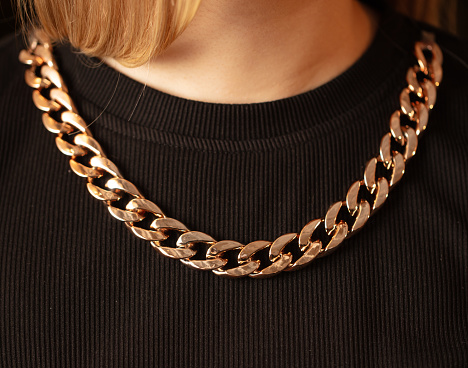 Close-up of a gold chain on a girl's neck.