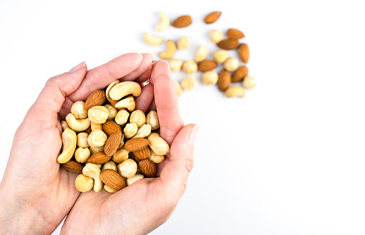 Woman's hands hold a mix of dried nuts. Healthy food concept. Close-up. Top view.