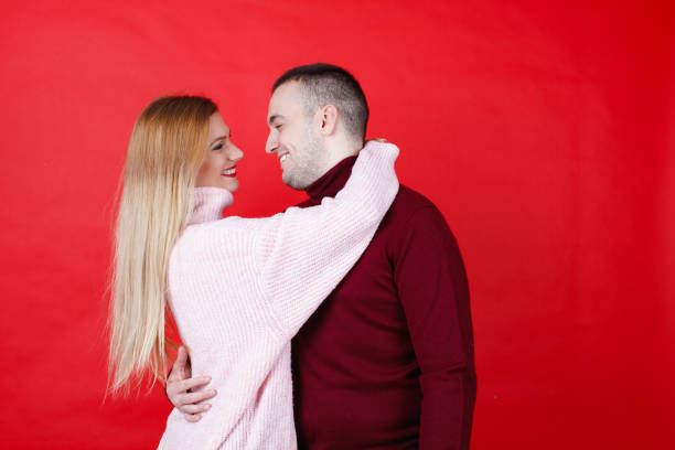 istock Young couple in turtleneck sweaters smiling at each other 1959808702