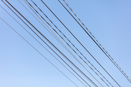 Electric wires against the blue sky.