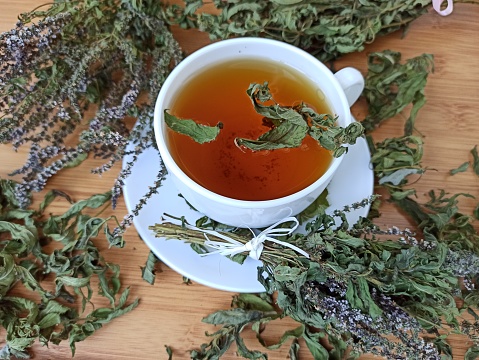 Person is drinking hot tea with lemon, thyme and honey