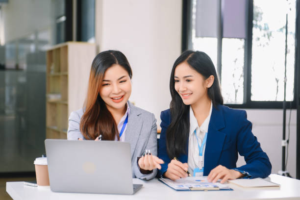 istock Asian business colleague business presents and explains and using laptop and tablet. Teamwork, financial marketing team, 1959833229