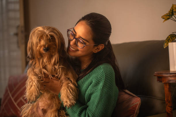 istock Smiling woman embracing dog on sofa 1959836961