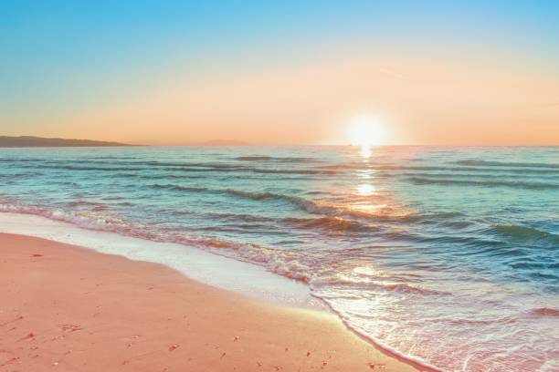 istock Colorful sunset viewed from the pink sea beach with soft waves 1959848110