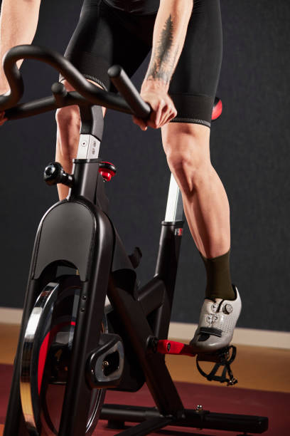 istock A young man on an exercise bike with a beard on a dark background.Training on an exercise bike in the gym. 1959848130