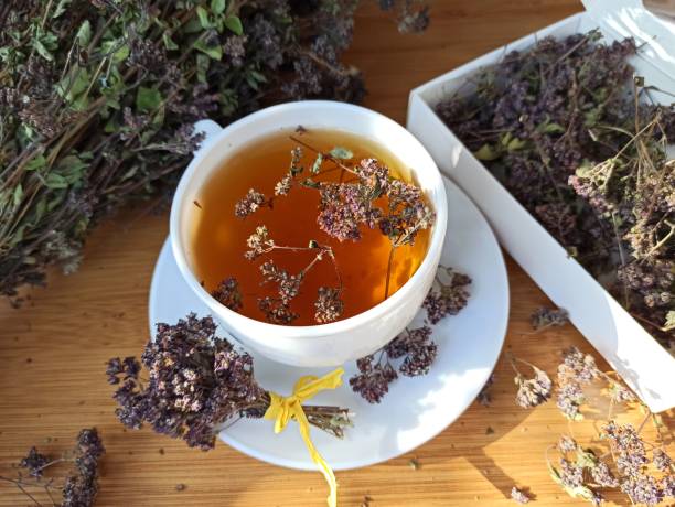 istock Tea drink with oregano leaves and flowers in a composition on the table, gift, top view 1959855555