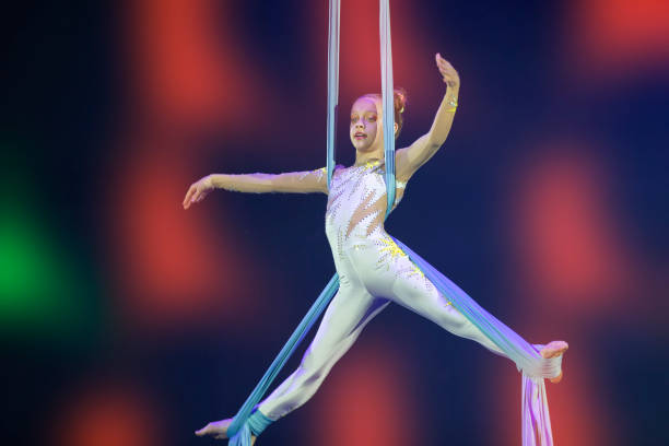 istock Performance by a circus acrobat artist. Girls perform aerial acrobatic elements on fabric. 1959863650