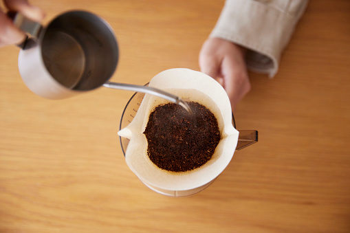 A woman's hand pouring coffee