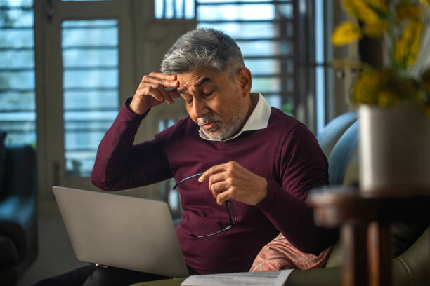 istock Worried old man using laptop at home 1959893795