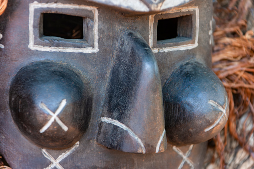 close up of traditional wooden vintage african mask with square eyes and large nose