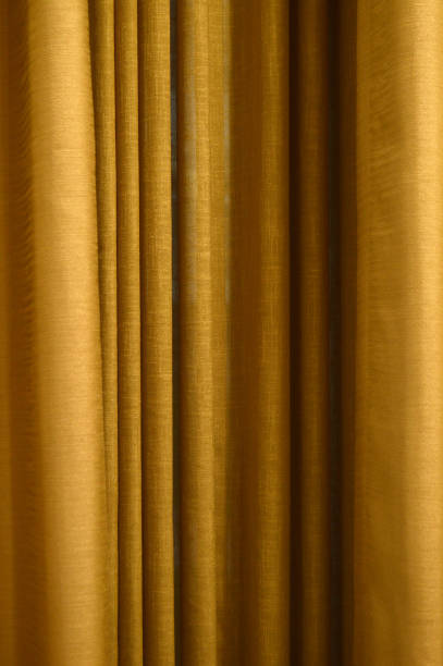 istock Bright rust or bronze brown coloured textured fabric pleated curtains that has curled up simple and elegant retro style vintage classic squiggled ribbed pleats making a wallpaper or vertical background 1959911400