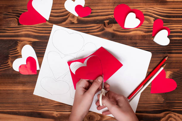 istock Valentines diy. Step by step instructions for handmade valentine. Craft gift, flat lay. Step 3. Cut your heart out of red paper, along lines. 1959971293