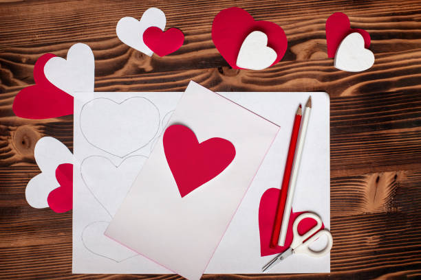 istock Valentines diy. Step by step instructions for handmade valentine. Craft gift, flat lay. Step 4. Heart of red paper. Preparation for creation of valentine, paper garland of hearts, postcard 1959972400