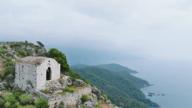Aerial view of old ruined chapel or church with sea view on the top of the mountain in Kayakoy, Fethiye