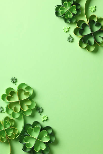 istock Saint Patricks Day vertical background. Flat lay paper art and craft style four-leaf clover on green background. Top view. 1959988512