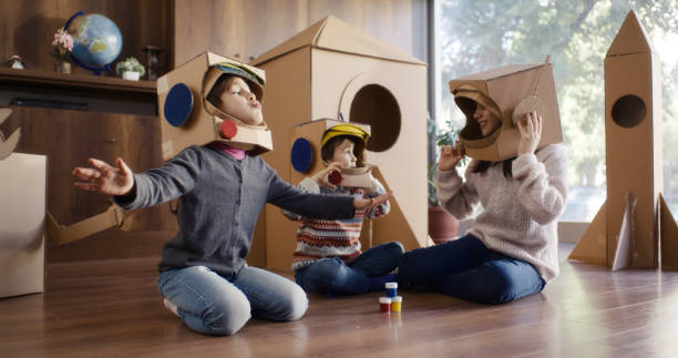 Children playing role play game as astronauts on mars and examining stone samples.