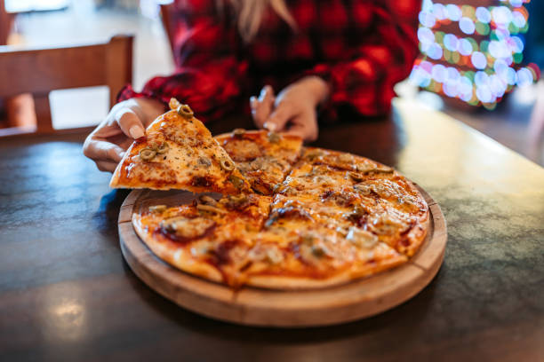 Young woman eating pizza in a pub.