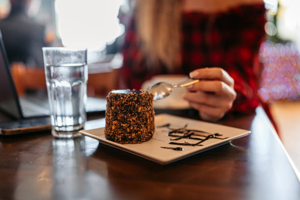 Young woman eating a chocolate dessert in a pub.