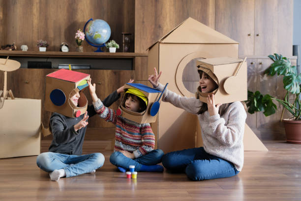 istock Children playing role play game as astronauts on mars and examining stone samples. 1960043033