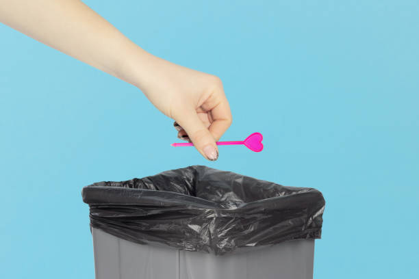 istock throw the skewer for appetizer, skewer for appetizer, plastic skewer for canapes in hand in front of the trash can,   recycling concept 1960046475