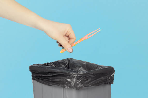 istock throw the skewer for appetizer, skewer for appetizer, plastic skewer for canapes in hand in front of the trash can,   recycling concept 1960046623