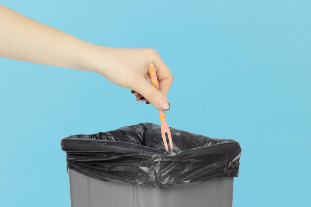 istock throw the skewer for appetizer, skewer for appetizer, plastic skewer for canapes in hand in front of the trash can,   recycling concept 1960046627