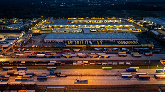Huerth, Germany - November 22, 2023: Railyard, freight station and freight trains at Koeln - Eifeltor at dusk. Aerial view