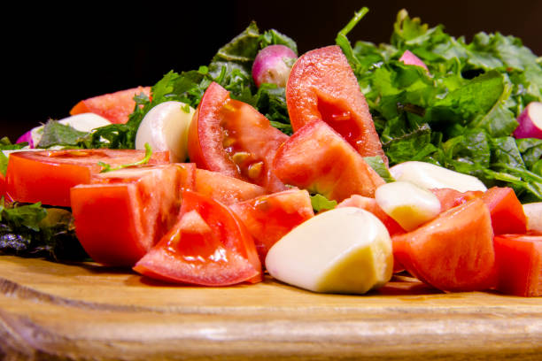 Appetizing salad: parsley, dill, basil, garlic and red tomatoes closeup. Background for cafes, restaurants, menu