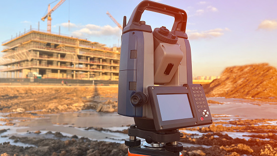 Electronic total station construction of houses, State-of-the-art surveying tool on construction site.