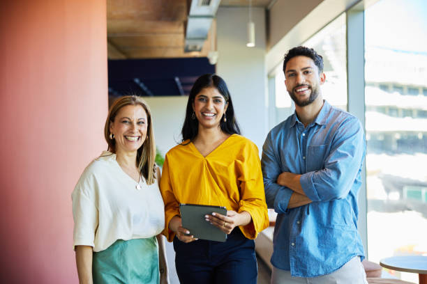 istock Diverse group of businesspeople smiling while standing in an office hallway 1960081573