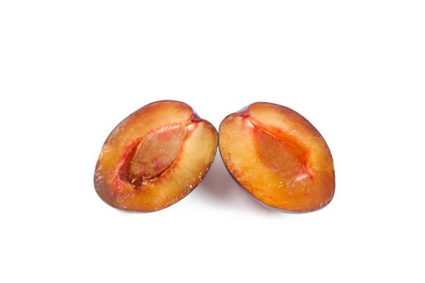 Juicy summer plum fruit. Halves ripe sweet plum isolated on white background.