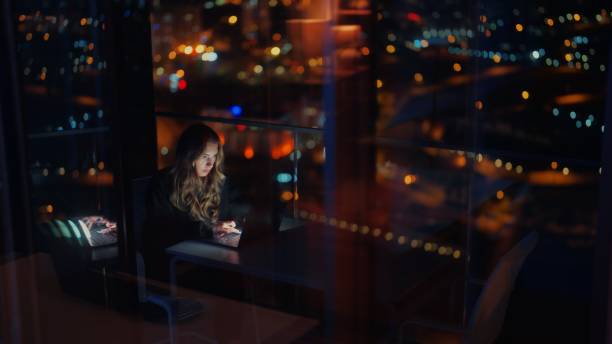 Young woman sitting at balcony and using laptop at home