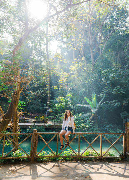 istock Woman enjoys refreshing  waterfall in tropical forest 1960118116